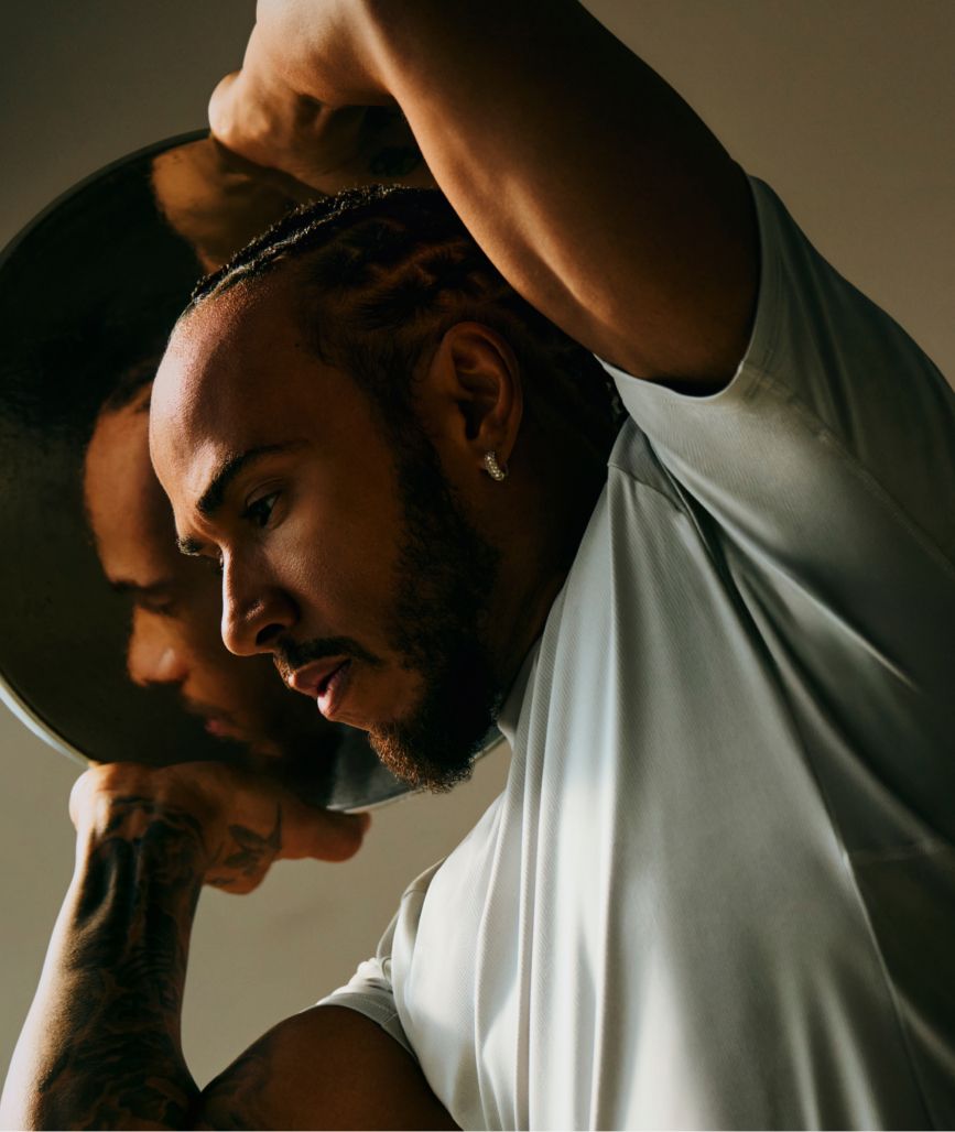 Lewis Hamilton wearing lululemon License to Train Top with a weight plate