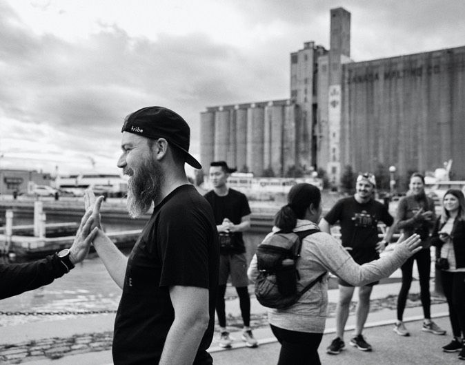 A group of people are exchanging high fives outside.