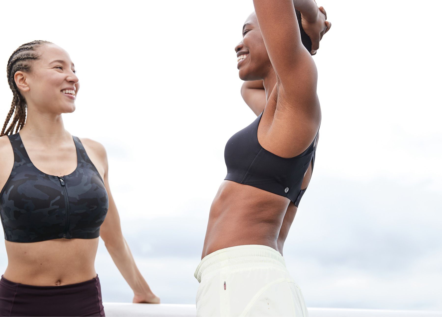 A woman holds the zipper on the Enlite Front Zip Bra