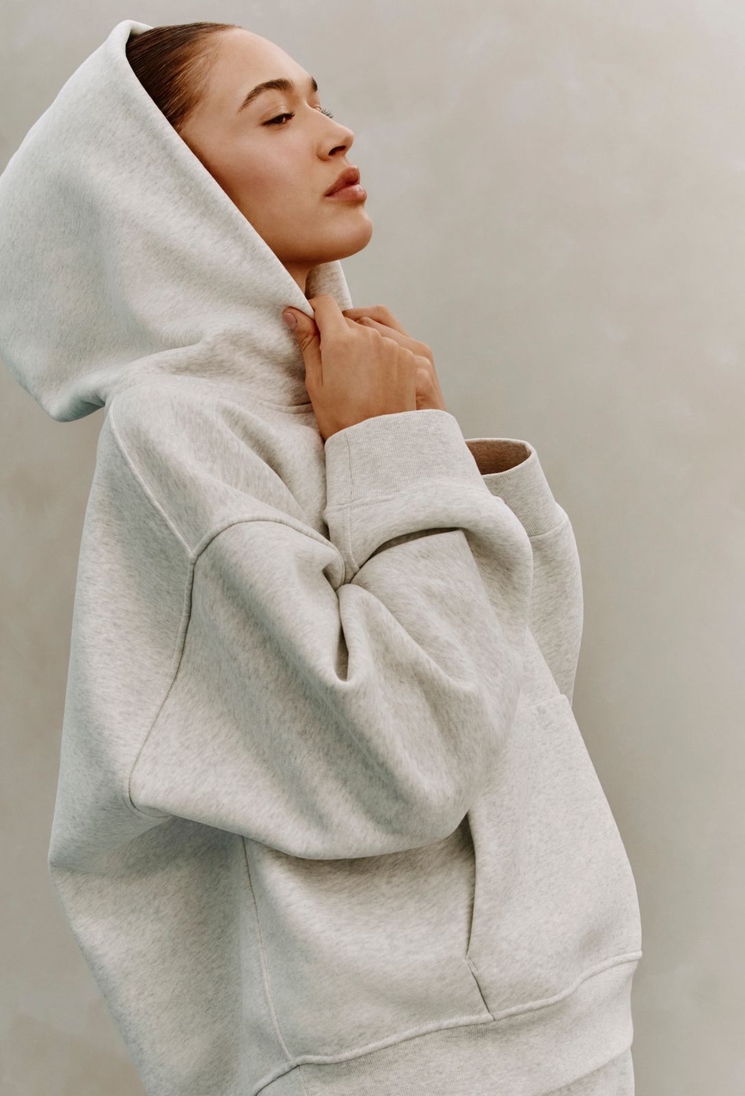 A person wears the Steady State SuperLoft™ Hoodie, with the hood on.