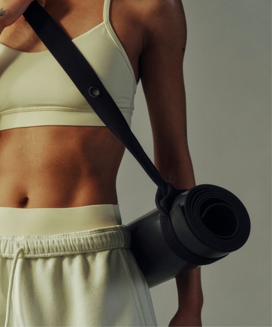 A person carries a yoga mat with the Loop It Up Mat Strap from lululemon.