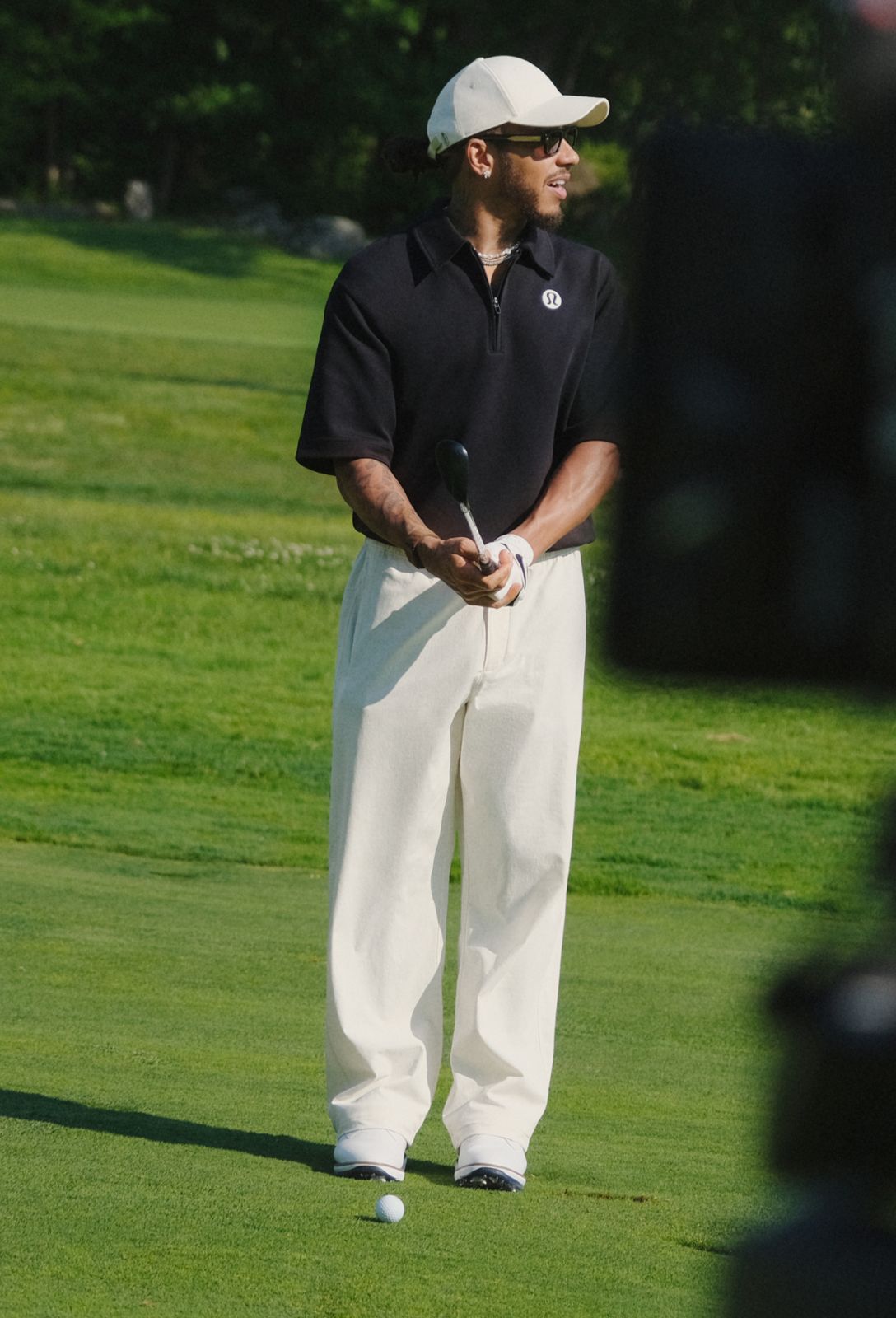 Seven-Time World Champion and lululemon Ambassador Lewis Hamilton wears the Grand Standard Short-Sleeve Polo and Unshaken Relaxed-Fit Pant from lululemon on a golf course.