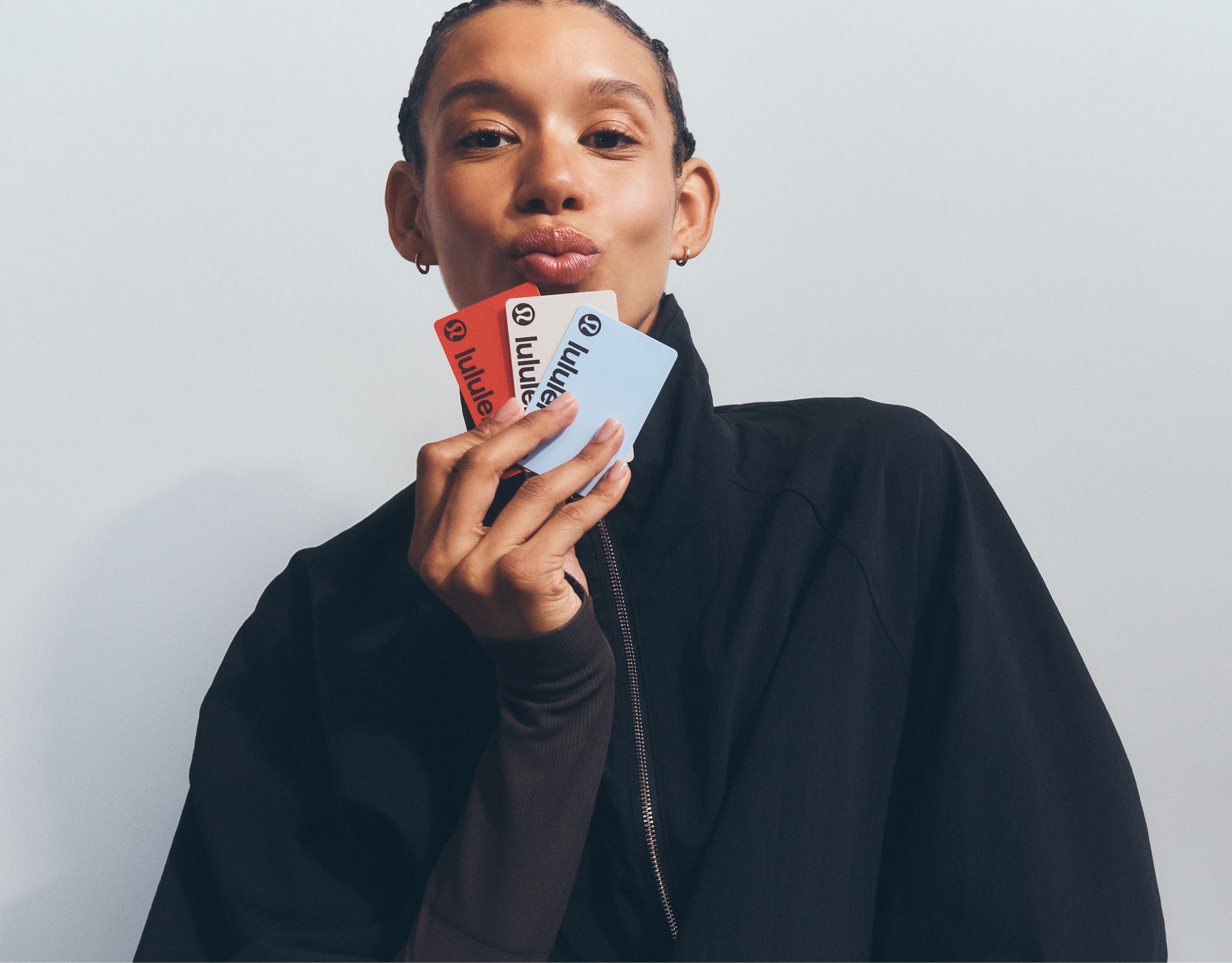 A mom holding lululemon gift cards.