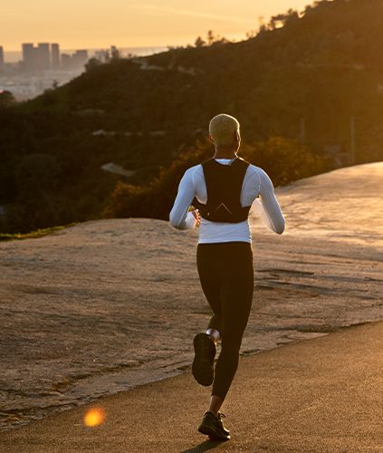 Woman wearing the Hydrafnity Vest running on a road.