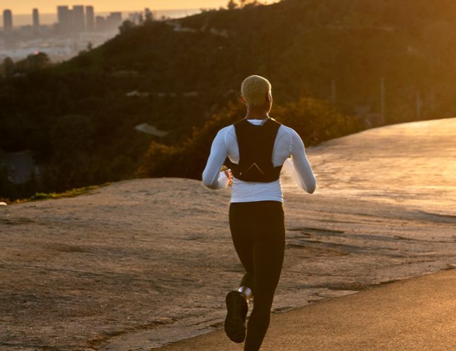 Woman wearing the Hydrafinity Vest running on a road.