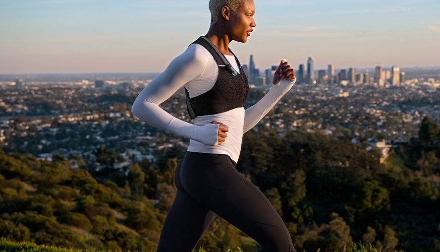 Woman wearing the Hydrafinity Vest overlooking a city skyline.