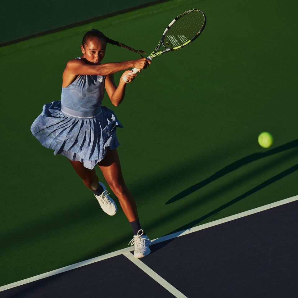 Pro Tennis Player and lululemon Ambassador Leylah Fernandez hits a forehand on court, wearing the new Paisley-Mesh Pleated Tennis Dress.